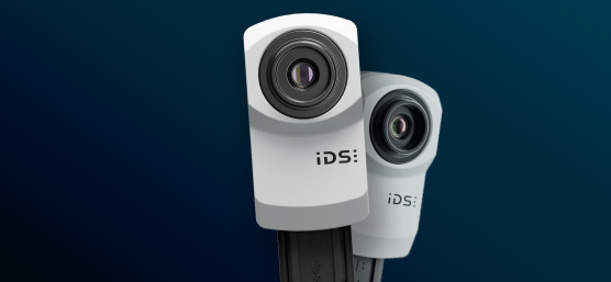 파란색 배경에 두 대의 IDS uEye XC 산업용 카메라.